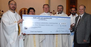 El párroco de la iglesia, Miguel Segura (Izquierda) entregó el cheque de 65 dólares a William Dunlop, contralor de la Arquidiócesis (Ultimo de la derecha) en presencia de otros sacerdotes.