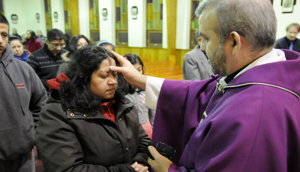 El Padre Ricardo Quiñones impone la ceniza.