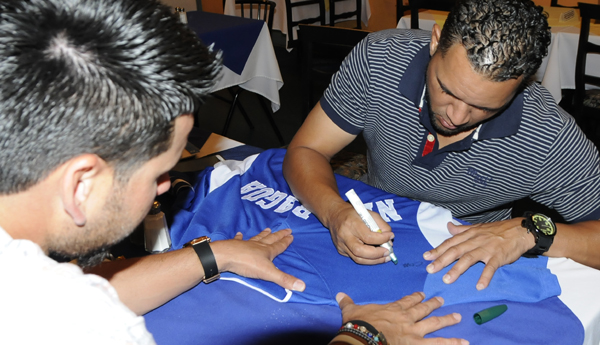 Jugadores de la selección de béisbol de Nicaragua firman la camiseta.