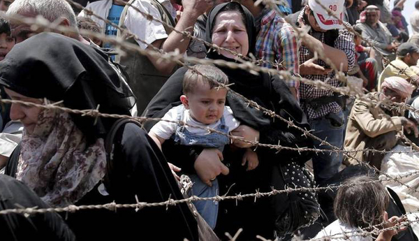 Sirios desesperados buscan cruzar frontera que los separa de Turquía.