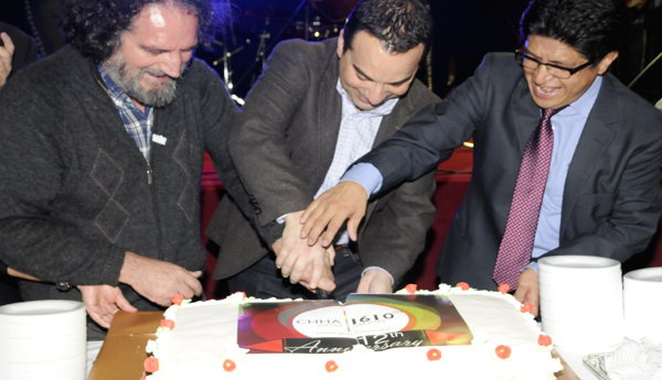 El Padre Hernán Astudillo (izq.), el MP Michael Levitt y el Cónsul de Ecuador, Rolando Vera cortan la torta de cumpleaños.